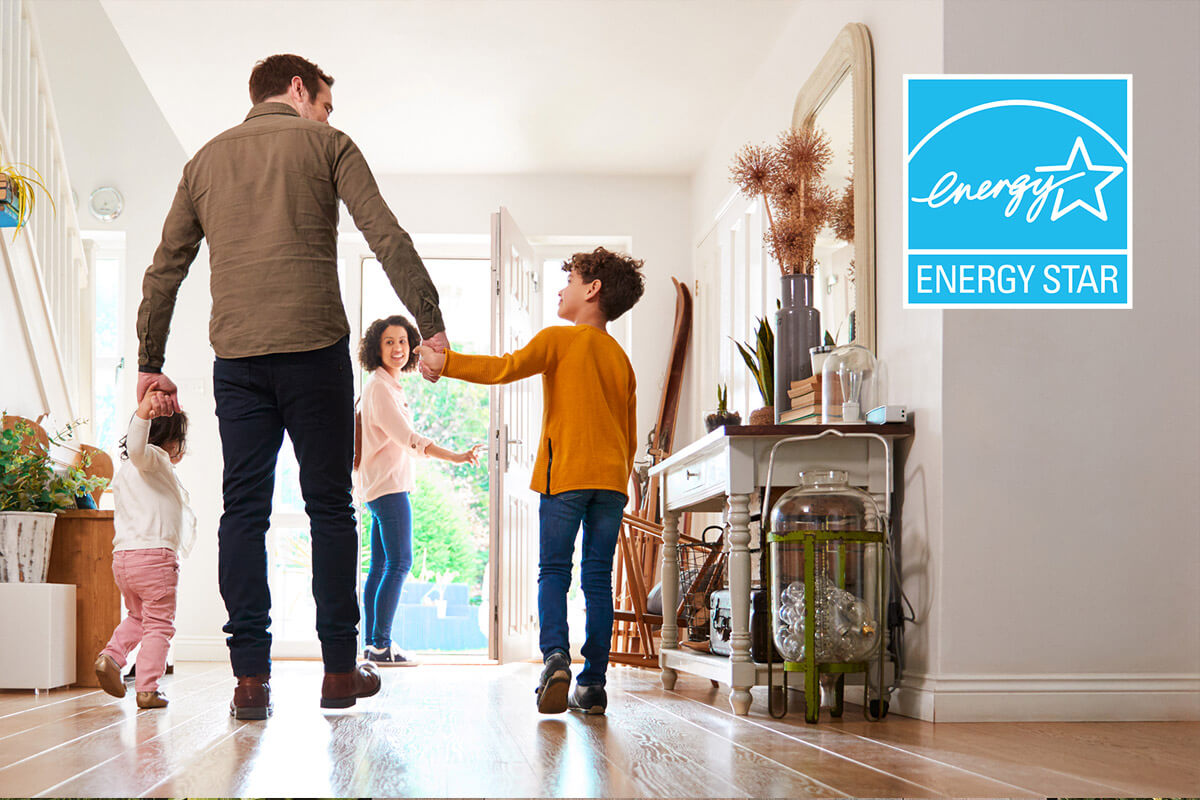 A father holds hands with his children as his wife opens the front entry door for them to go outside.