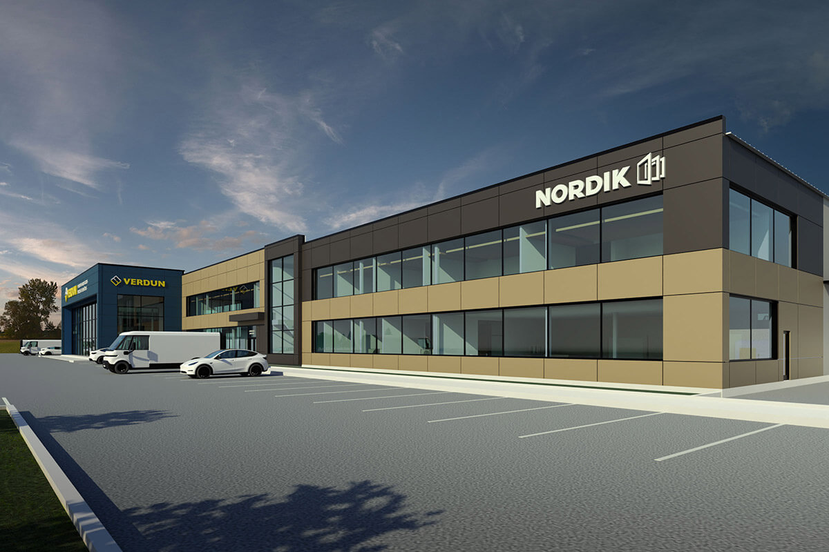 Modern office building with large windows and NORDIK signage on the front with several parked cars and an empty lot—future site of the new Nordik production plant 2026—under a partly cloudy sky.