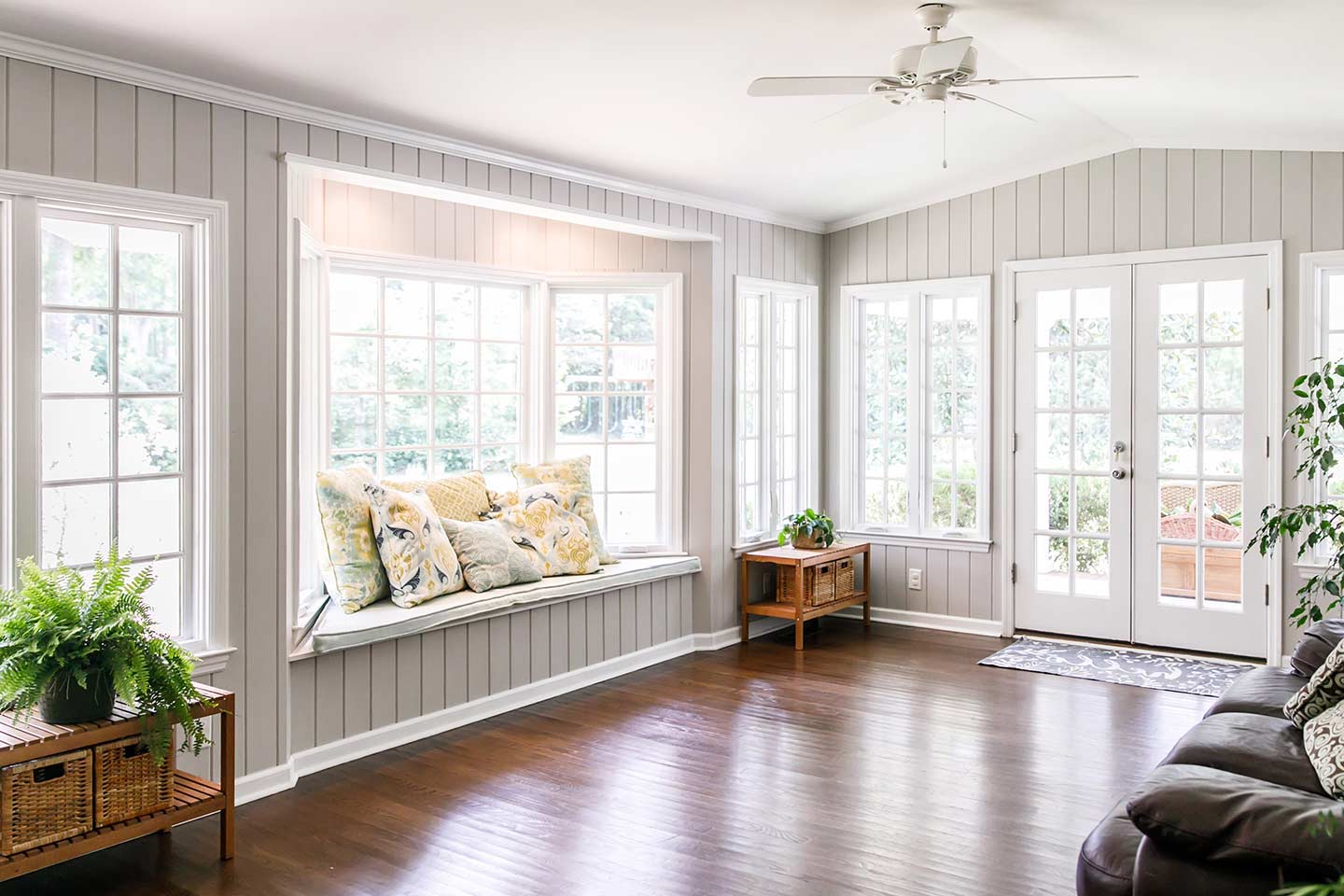 Gorgeous bay window with seat in a sunroom creates a cozy space for relaxation