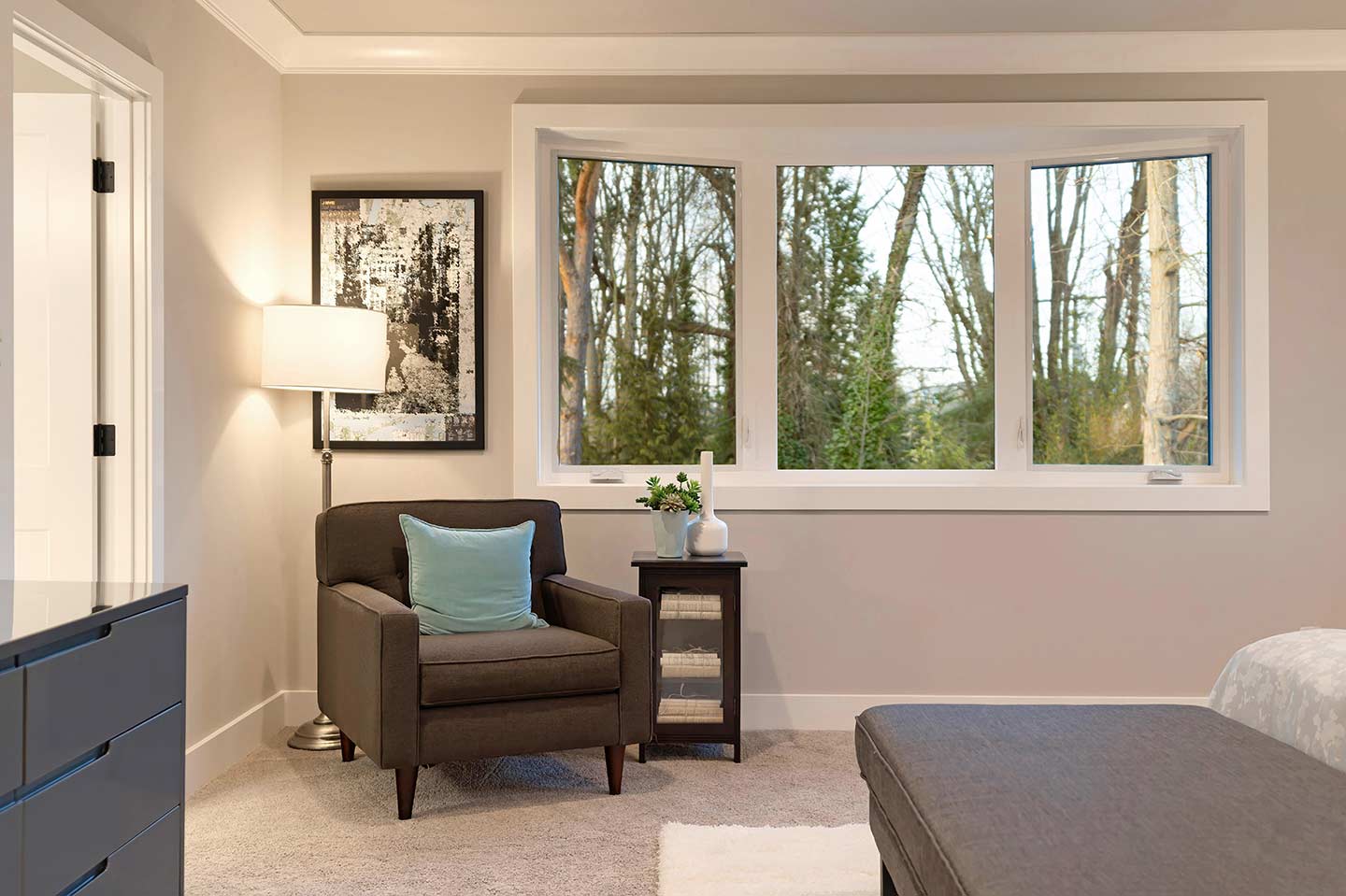 3-lite bow window with seat in a bedroom provides a panoramic view outside and extra sill space