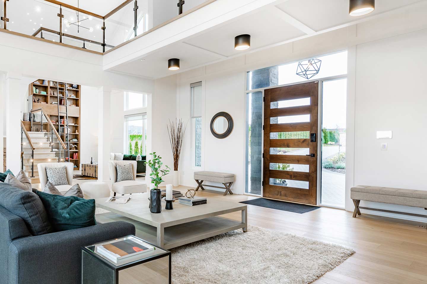 beautiful contemporary fiberglass door with glass inserts, side lites, and transom, in an open-concept new home