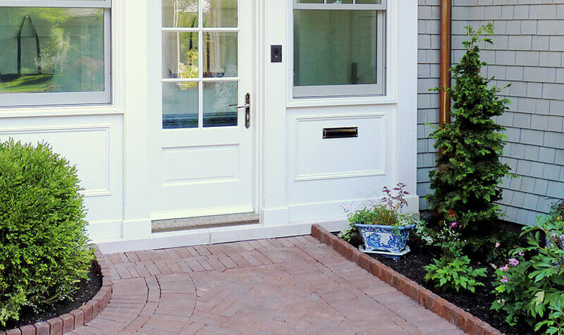 A white residential door with custom granite sill
